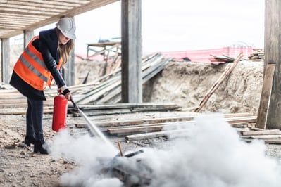 Woman extinguishing fire on construction site