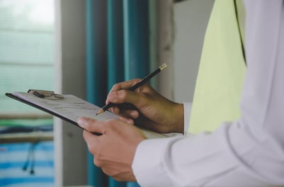 Person writing on a clipboard