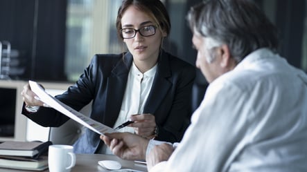 Woman explaining contract document to man