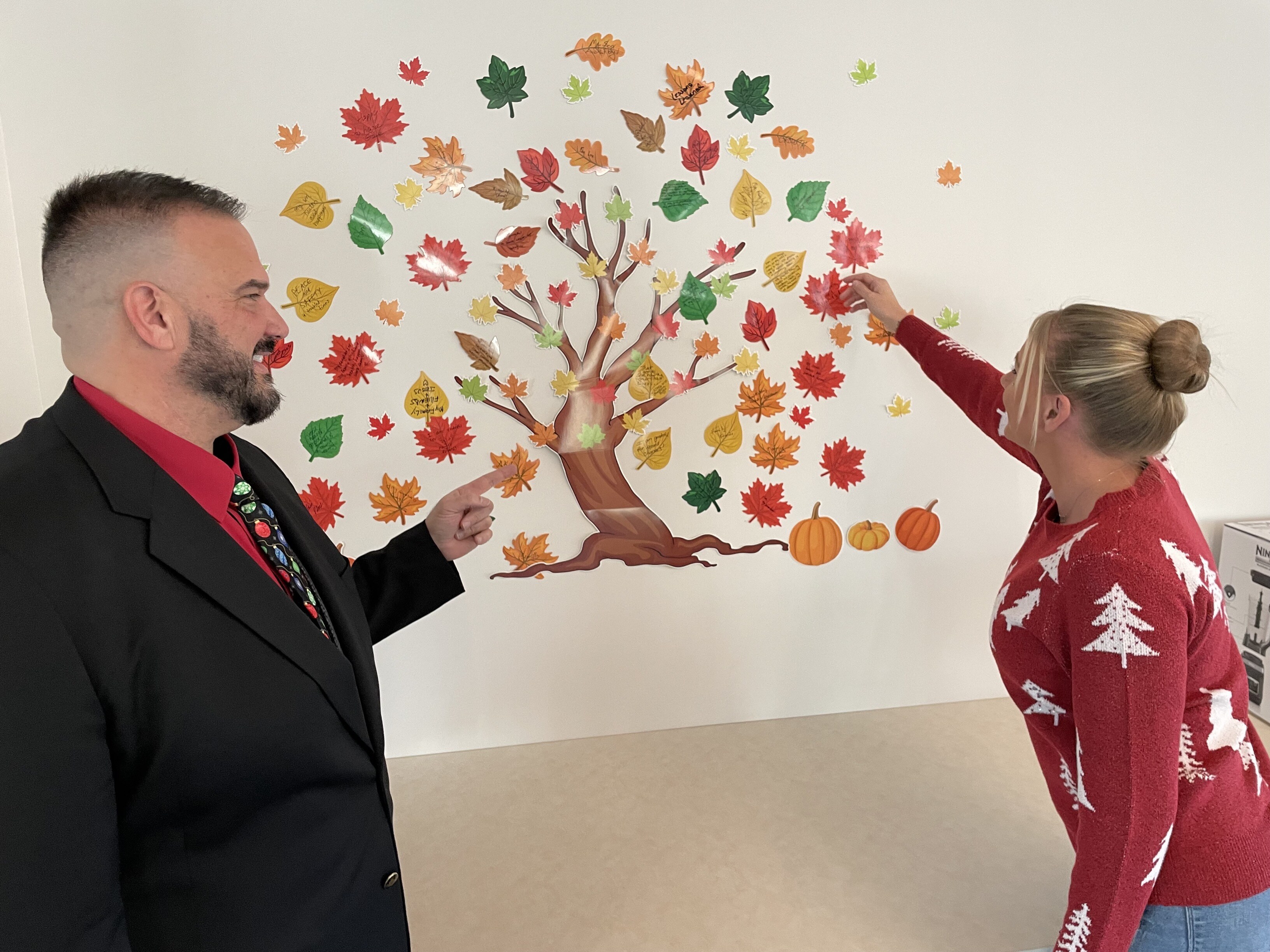 Samantha Thomas pointing at the Gratitude Tree as Ed Malaspina looks on. 