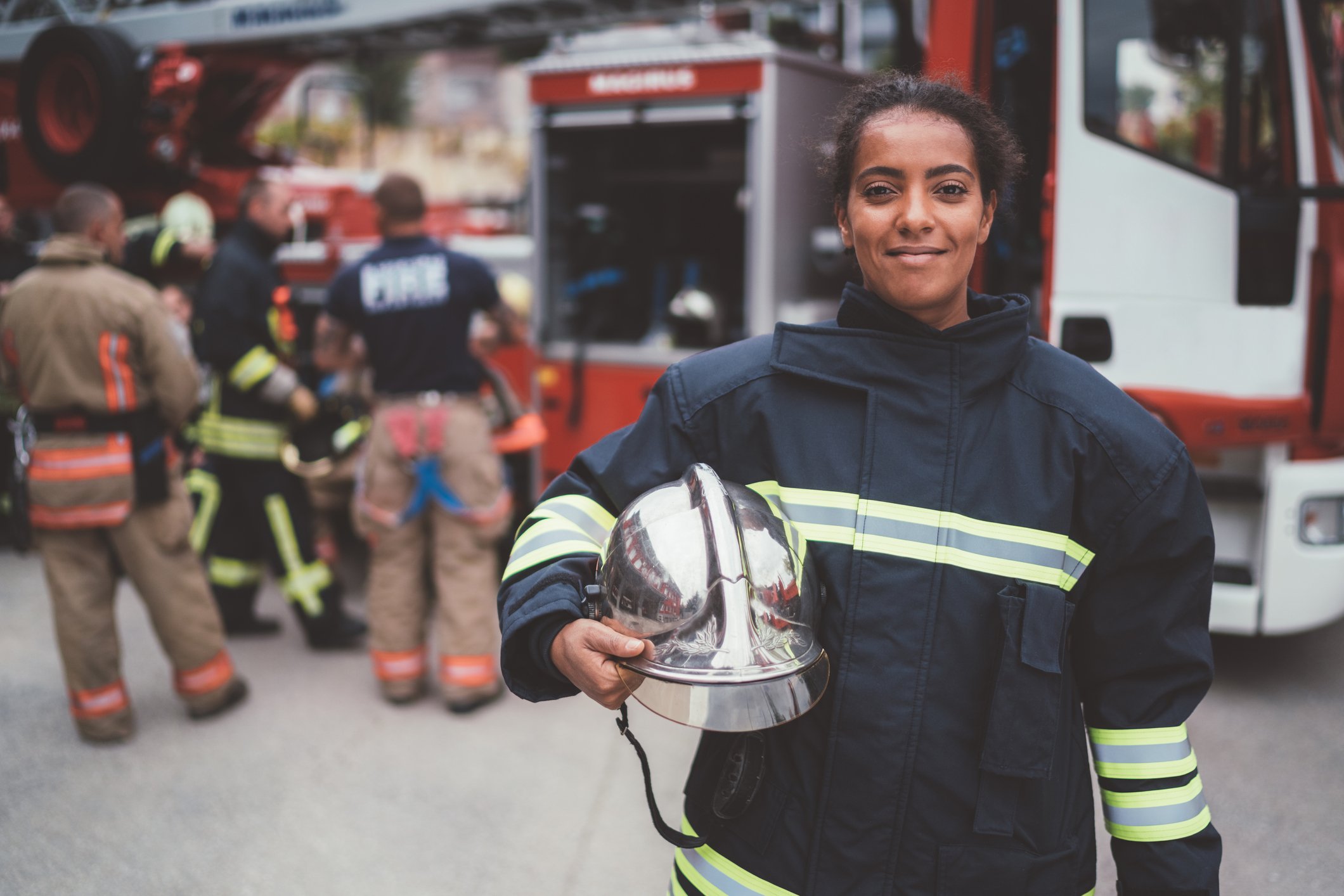 Female firefighter holding helmet