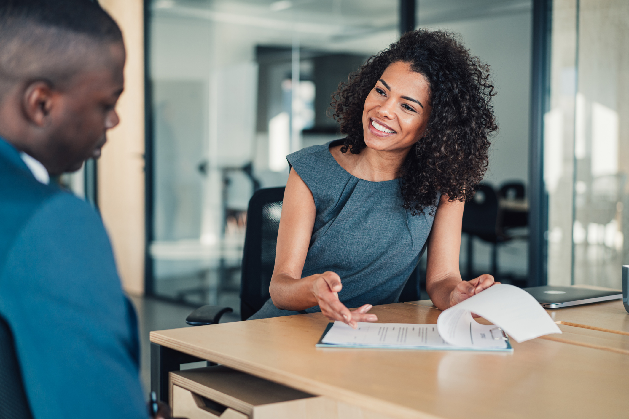 Woman explaining something to man at desk